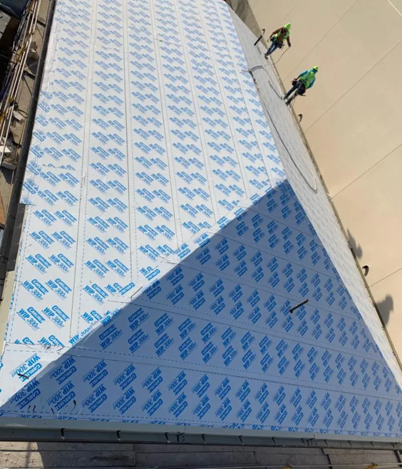 Professional roofers installing underlayment on a metal roof in Piscataway